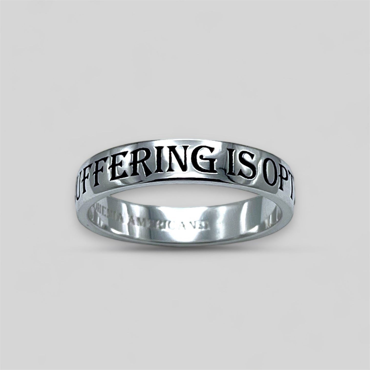 Platinum ring with engraved text on a light gray background