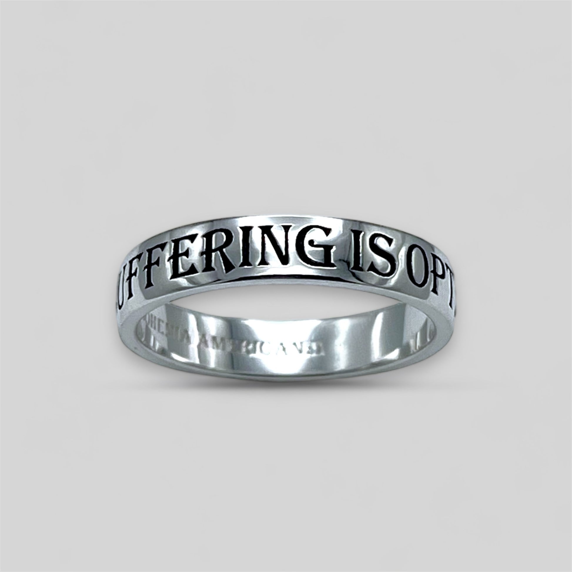 Platinum ring with engraved text on a light gray background